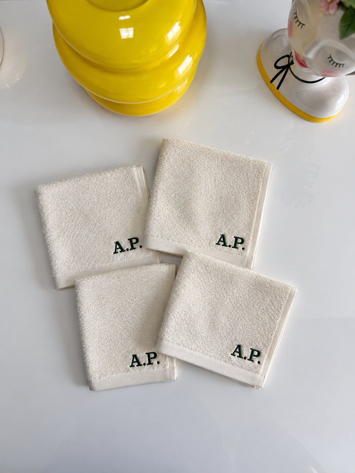 Set di quattro asciugamani colorate in cotone bianco con monogramma A.P., dimensioni 30x30 cm, ideali per cura quotidiana, in ambiente bagno elegante