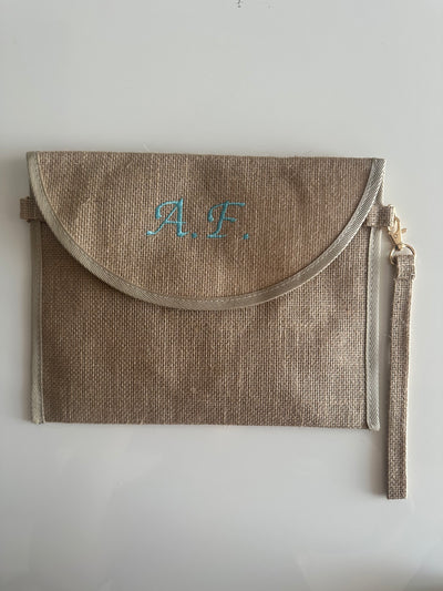 Pochette in juta personalizzata con iniziali, chiusura a patta e cinturino laterale, ideale come borsa elegante e sostenibile.