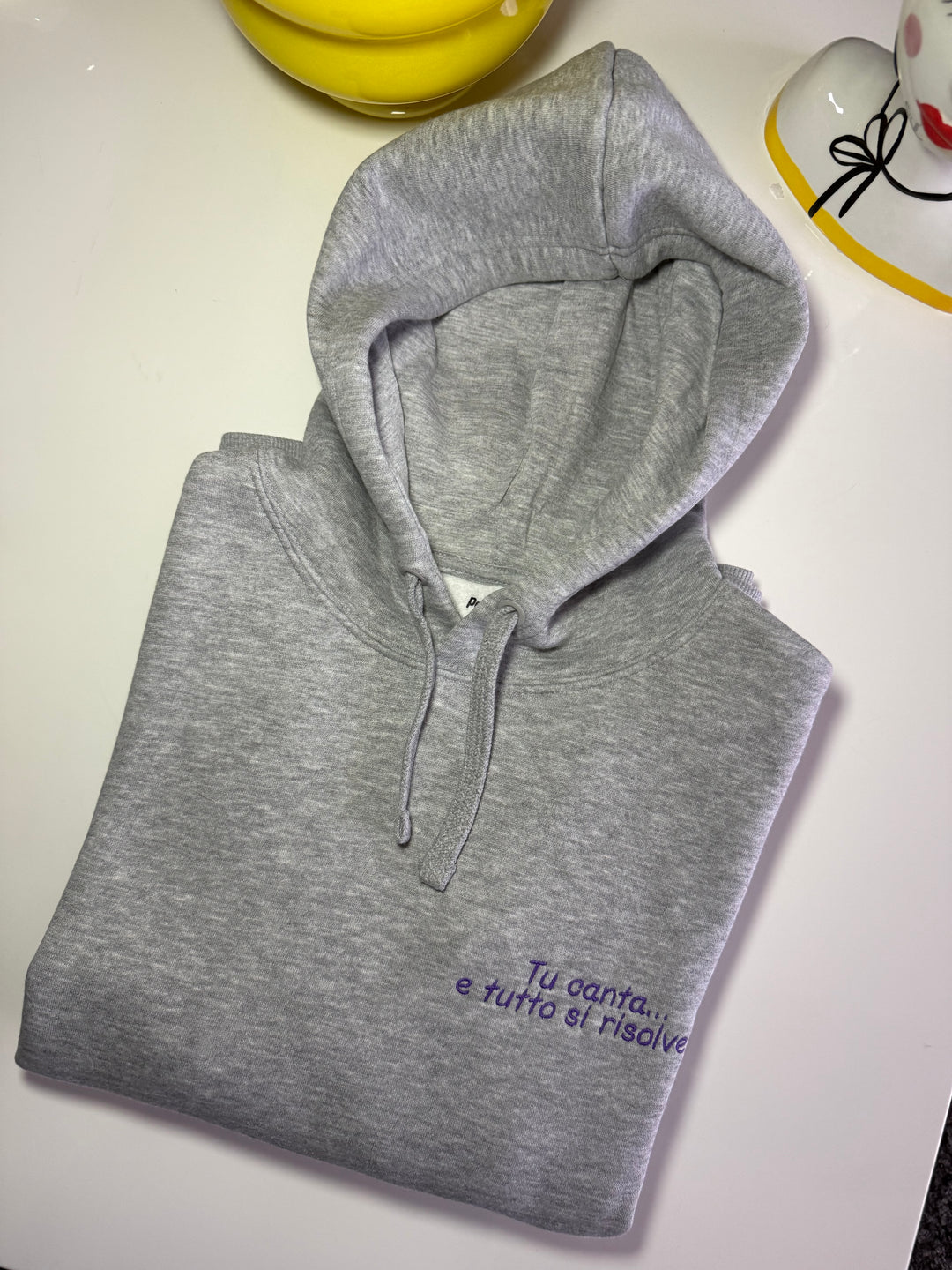 Felpa con cappuccio grigia con frase ricamata viola "Tu canta… e tutto si risolve"