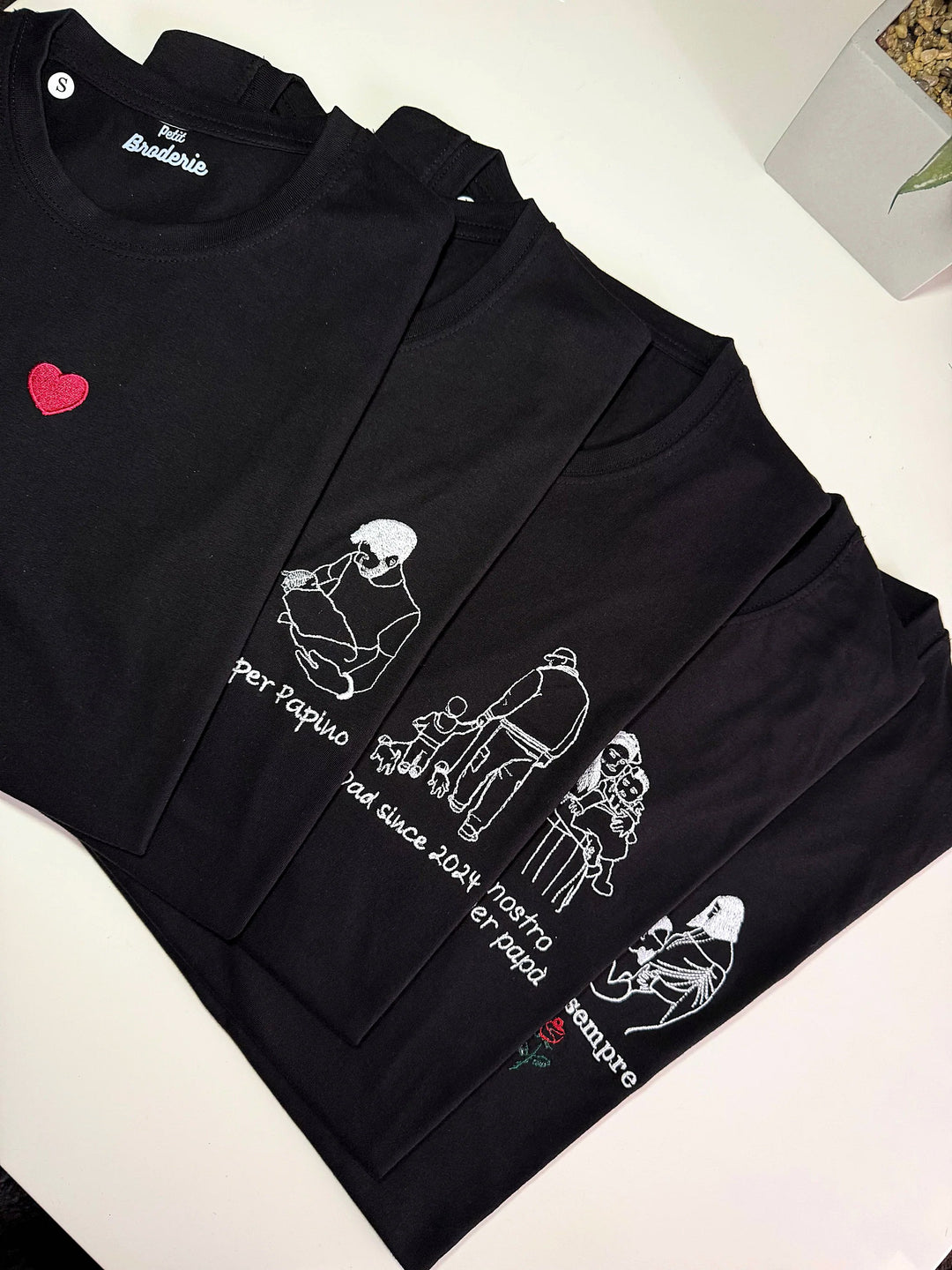 T-shirt nere con foto stilizzate di famiglia ricamate in bianco