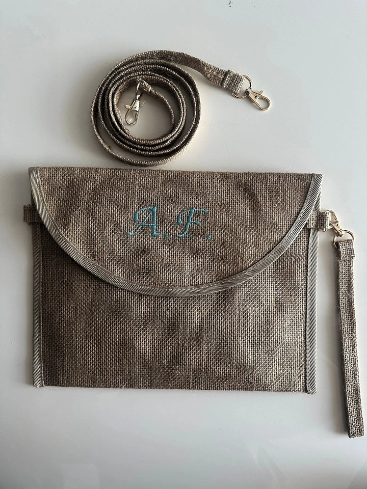 Pochette in juta personalizzata con iniziali, dotata di tracolla e cinturino removibili. Elegante borsa clutch ideale per ogni occasione.
